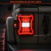 Close-up dramatic shot of jeep wrangler led tail lights installed on vehicle showing 3D red halo ring and white reverse light with wet ground reflection