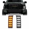 Pair of black honeycomb Tundra vent panels shown in amber and white below the front of a modified Toyota Tundra