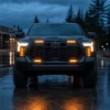 Front view of a Toyota Tundra on a wet road with amber vent panels grille accent lights and lower bumper lights illuminated