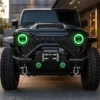 Front view of a black modified Wrangler with synchronized green halos glowing in the headlights and bumper fog lights