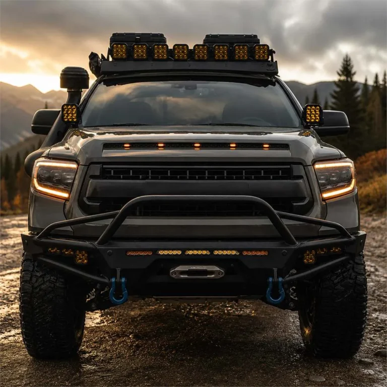Off-road truck facing forward with five amber hood markers illuminated below the scoop