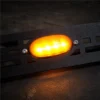 One illuminated amber LED secured to the black mesh insert with two screws