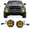 Pair of four-module yellow fog lights displayed below the front of a gray Toyota Tacoma with both bumper lights illuminated