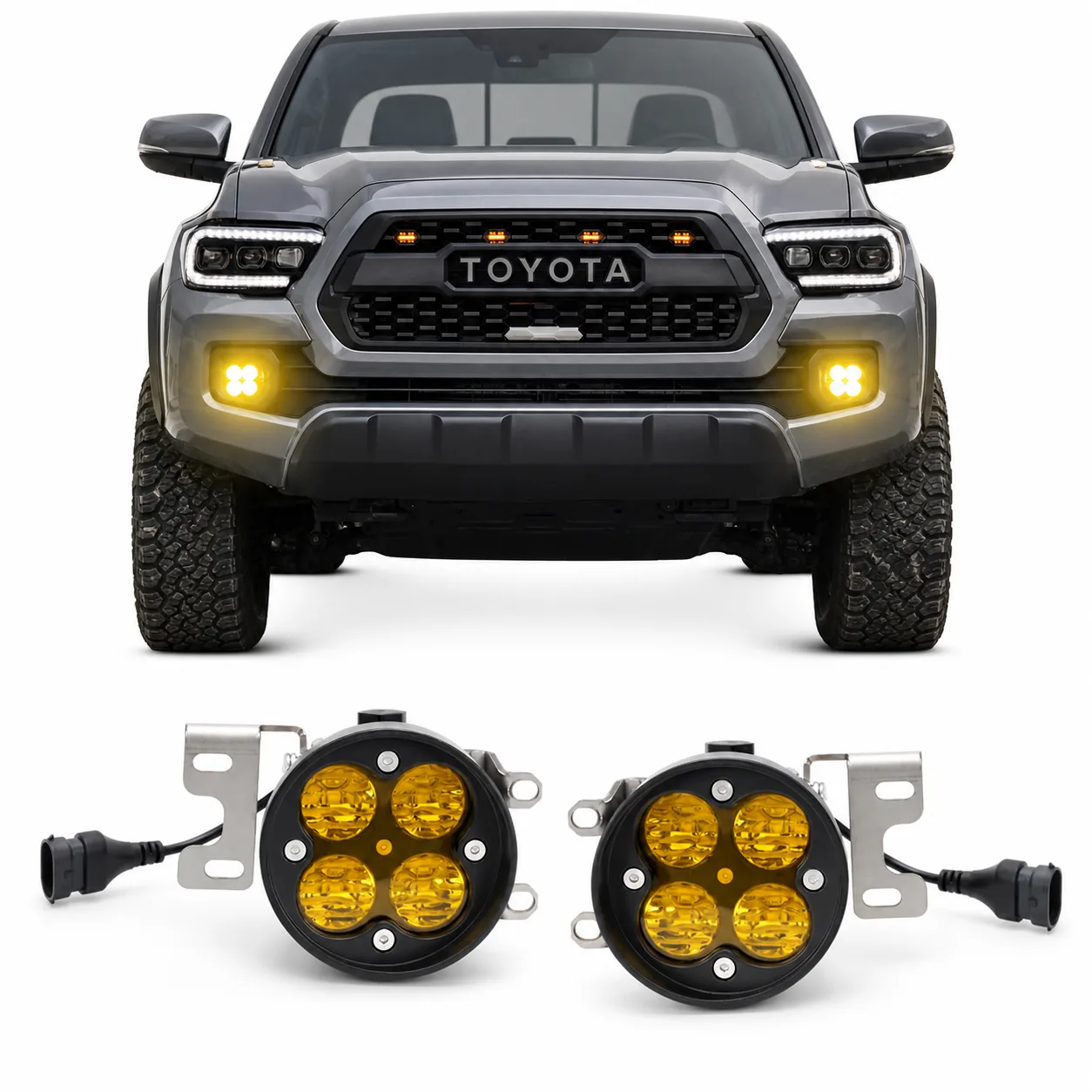 Pair of four-module yellow fog lights displayed below the front of a gray Toyota Tacoma with both bumper lights illuminated