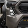 Close-up of white daytime running Tacoma fang light installed in the factory front bumper opening