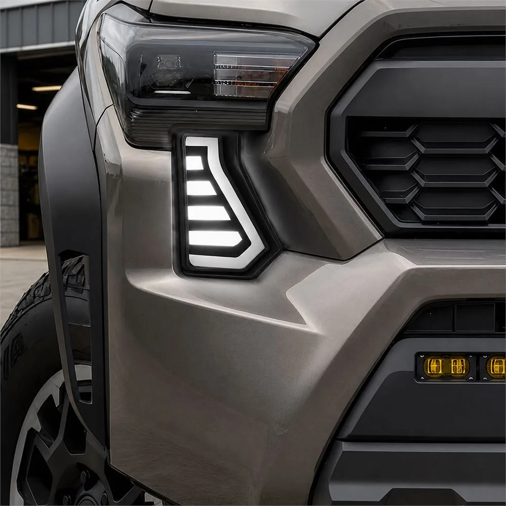 Close-up of white daytime running Tacoma fang light installed in the factory front bumper opening