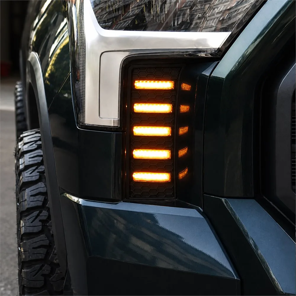 Close-up of five amber LED bars illuminated inside the black honeycomb vent panel beside a Tundra headlight