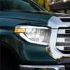 Close-up of a white perimeter DRL and amber side marker installed on a dark green Toyota Tundra