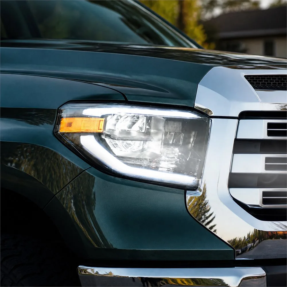 Close-up of a white perimeter DRL and amber side marker installed on a dark green Toyota Tundra
