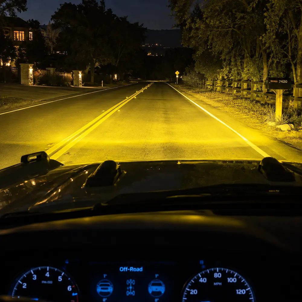Amber road illumination from triple fog lamps on a 2021-2026 Ford Bronco during night driving
