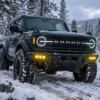 2021-2026 Ford Bronco fog lights providing amber visibility on a snowy off-road trail