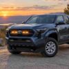 2024-2026 Toyota Tacoma with amber LED grille raptor lights at sunset outdoor scene