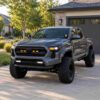 2024-2026 Toyota Tacoma SR SR5 with amber LED grille raptor lights installed in a residential driveway