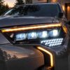 Close-up of a quad projector 4Runner headlight with white running light and amber signal illumination.
