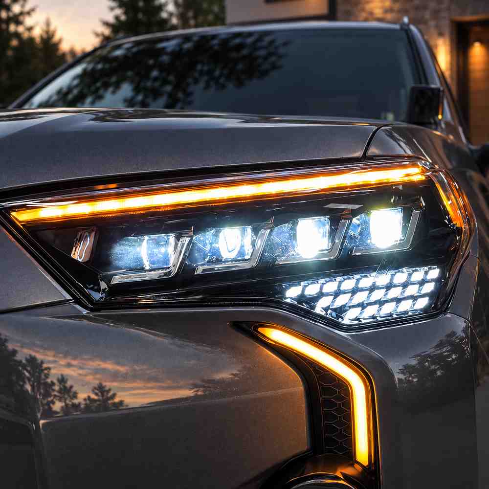 Close-up of a quad projector 4Runner headlight with white running light and amber signal illumination.