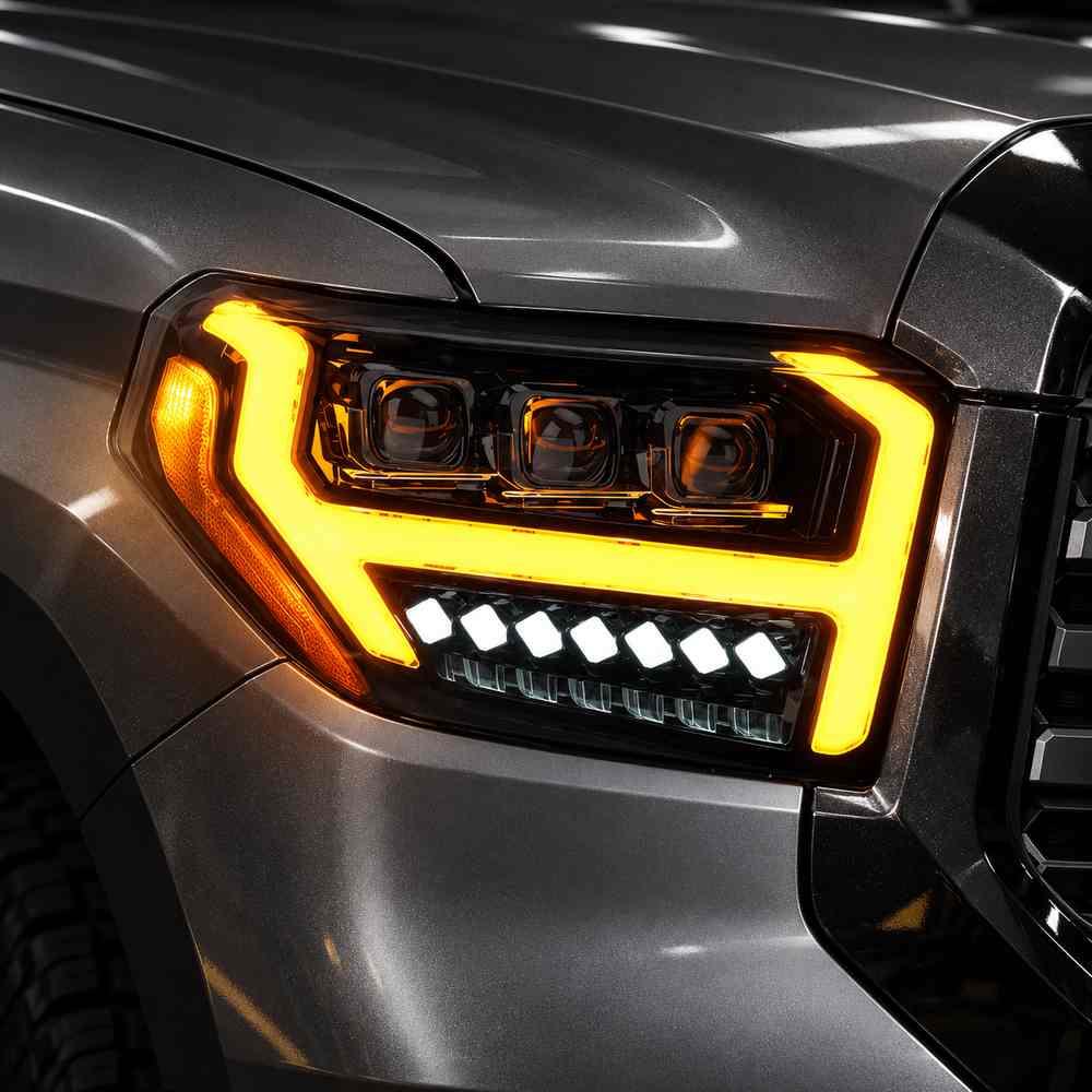 Toyota Tundra headlights showing amber sequential turn signal lighting around triple projector lenses